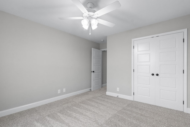 unfurnished bedroom with a ceiling fan, carpet, a closet, and baseboards