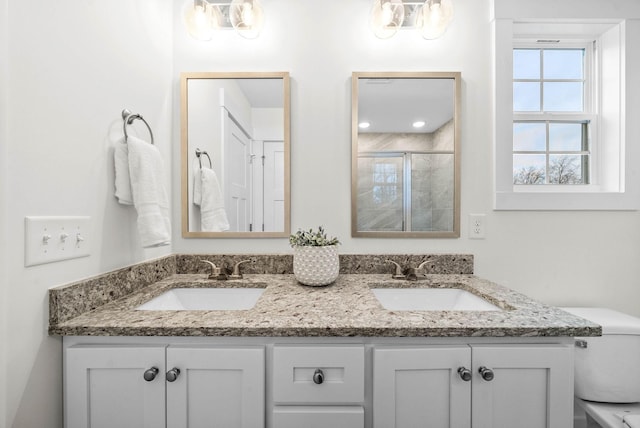 full bathroom with a shower stall, toilet, double vanity, and a sink