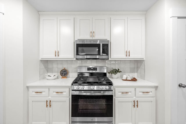 kitchen featuring backsplash, appliances with stainless steel finishes, and white cabinets