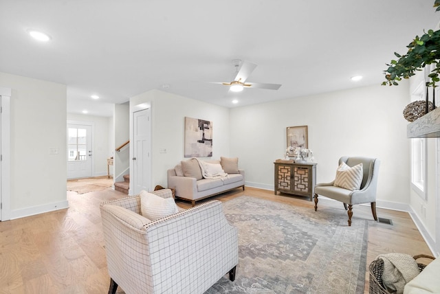 living room with light wood finished floors, recessed lighting, stairs, and baseboards