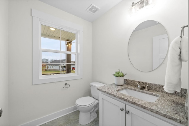 half bath with visible vents, baseboards, toilet, and vanity