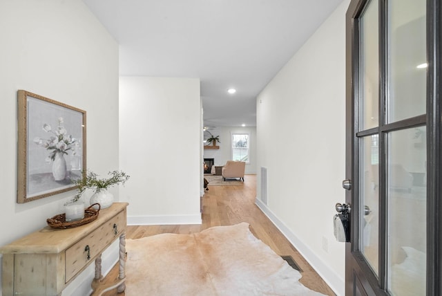 hallway featuring visible vents, recessed lighting, baseboards, and light wood-style floors