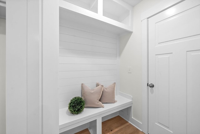 mudroom with wooden walls and wood finished floors