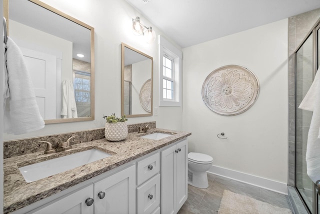 bathroom with toilet, an enclosed shower, baseboards, and a sink