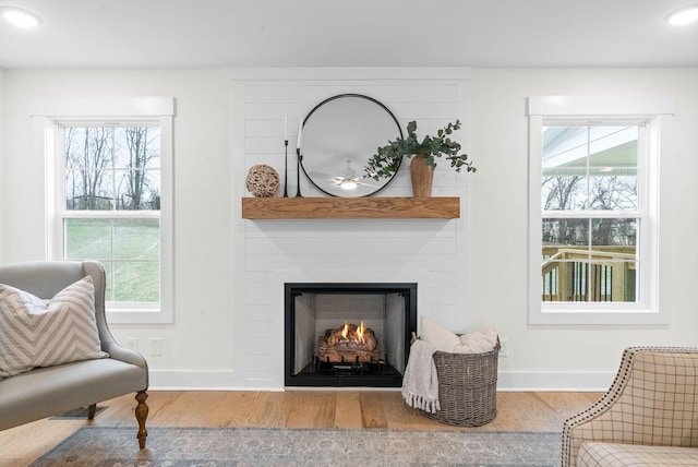 sitting room with a fireplace, recessed lighting, wood finished floors, and baseboards