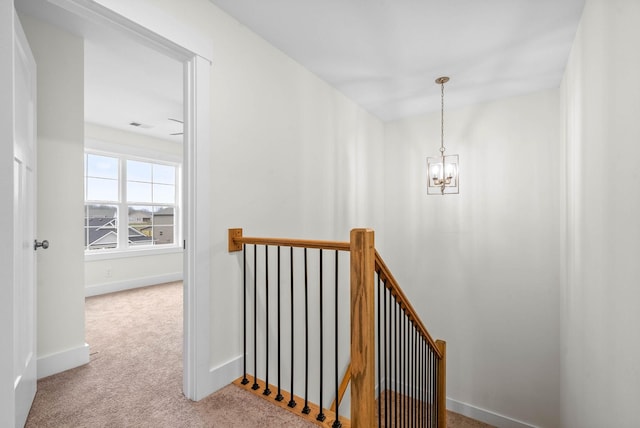 stairs with baseboards, carpet floors, visible vents, and a chandelier