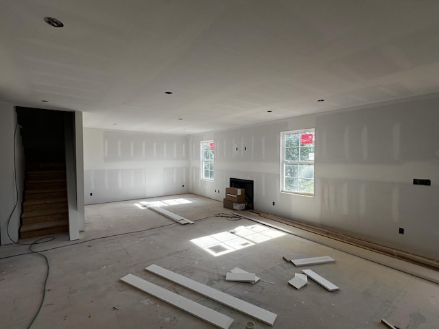 unfurnished living room with a fireplace and stairs