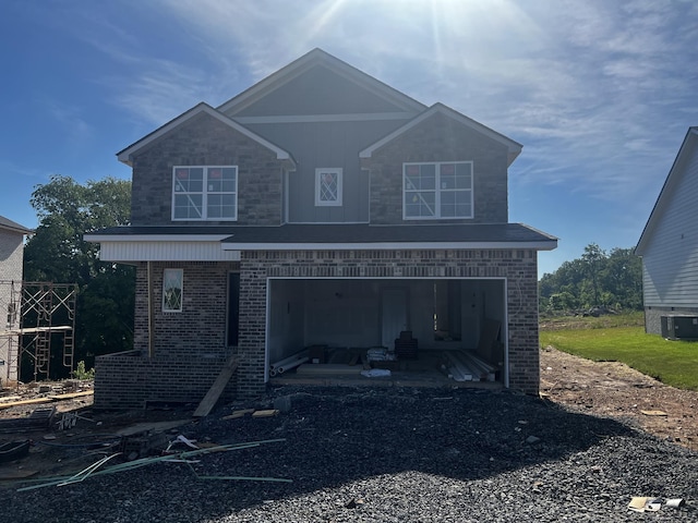 view of front of house with central air condition unit, an attached garage, and brick siding