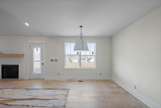 interior space with a fireplace, baseboards, and light wood-type flooring