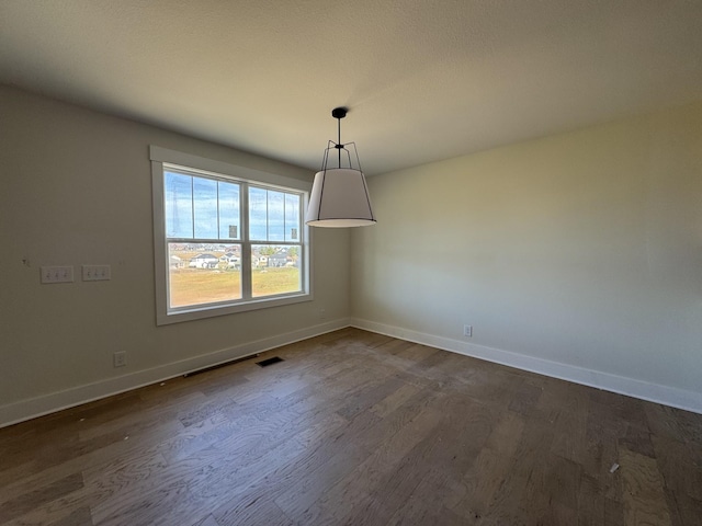 unfurnished dining area featuring visible vents, baseboards, and dark wood-style flooring