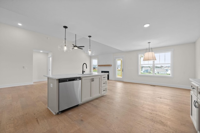 kitchen with light countertops, light wood-type flooring, a sink, dishwasher, and a ceiling fan