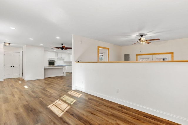 unfurnished living room with recessed lighting, baseboards, light wood-style floors, and a ceiling fan