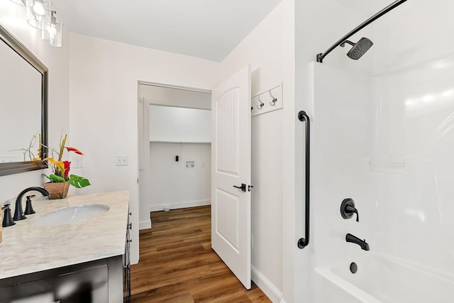 full bath featuring tub / shower combination, baseboards, wood finished floors, and vanity