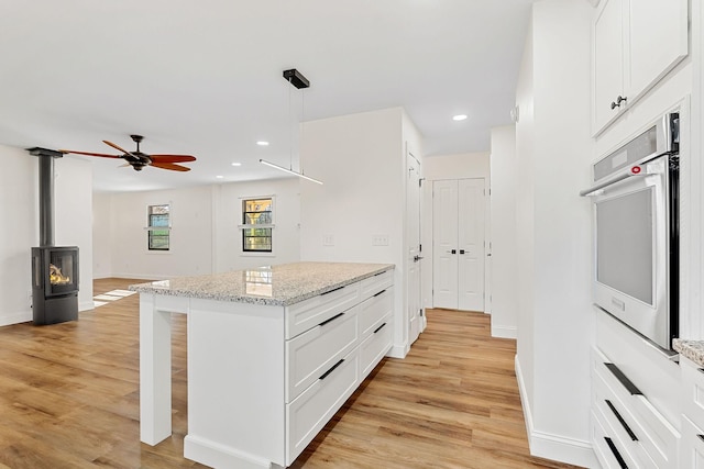 kitchen featuring white cabinetry, stainless steel oven, recessed lighting, and light wood-type flooring