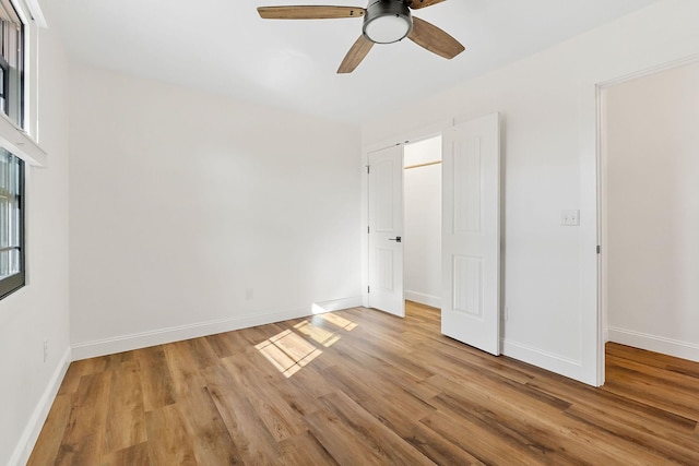 unfurnished bedroom featuring light wood-type flooring, baseboards, and ceiling fan