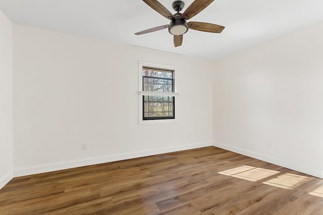 unfurnished room featuring baseboards, wood finished floors, and a ceiling fan