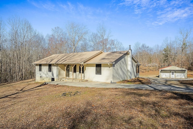 view of front of house featuring a detached garage, an outbuilding, and covered porch