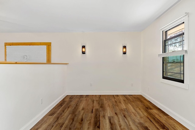 unfurnished room with baseboards and wood finished floors