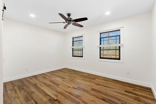 spare room featuring visible vents, baseboards, recessed lighting, wood finished floors, and a ceiling fan