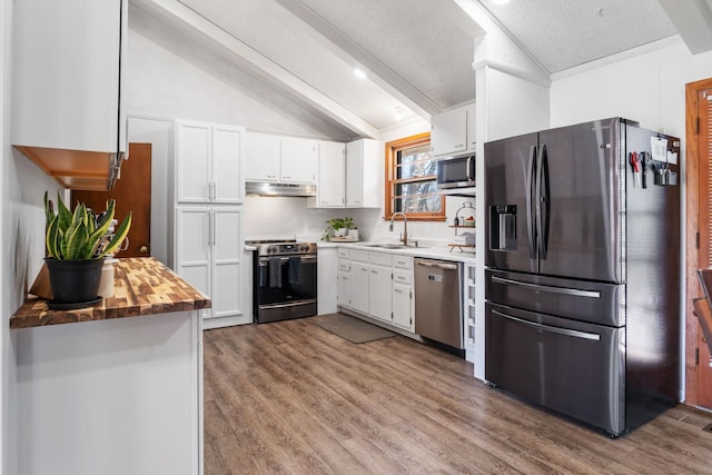 kitchen featuring lofted ceiling with beams, a sink, white cabinetry, appliances with stainless steel finishes, and dark wood-style flooring