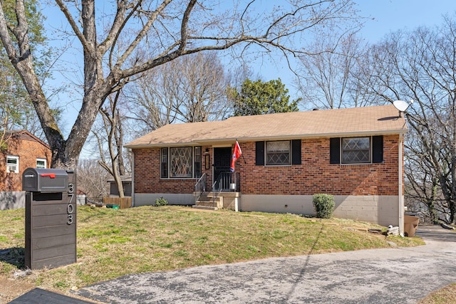 single story home with a front lawn, brick siding, and a shingled roof