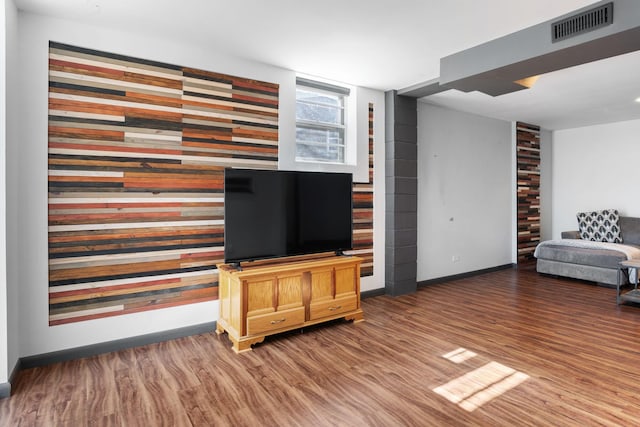 living area with visible vents, baseboards, and wood finished floors