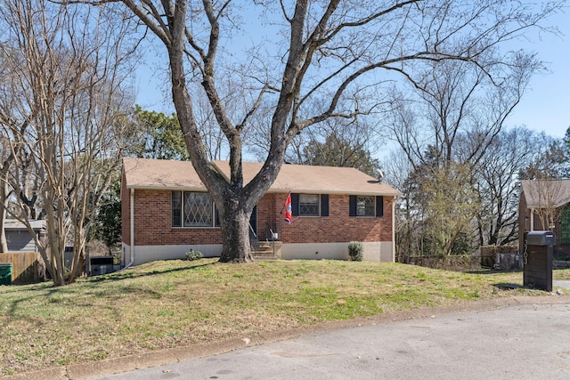 ranch-style house featuring brick siding, a front lawn, and fence