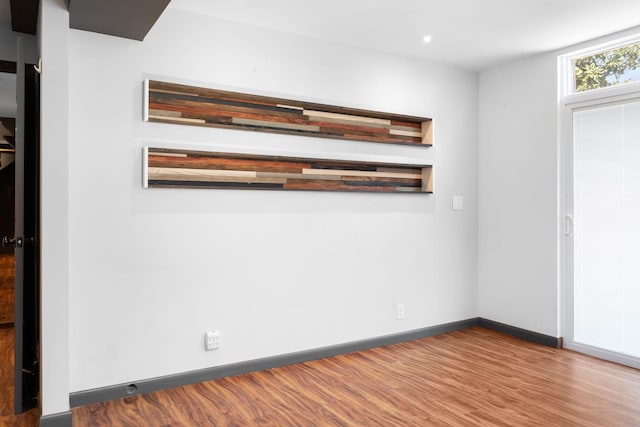 unfurnished room featuring recessed lighting, wood finished floors, and baseboards