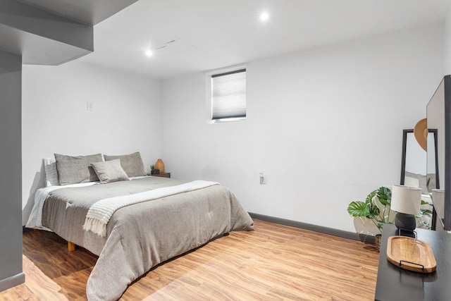 bedroom with baseboards and wood finished floors