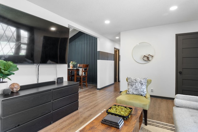 living room with recessed lighting, baseboards, and wood finished floors