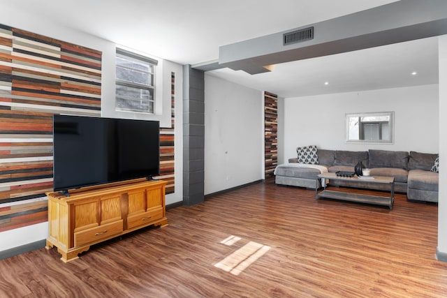 living room with visible vents, baseboards, and wood finished floors