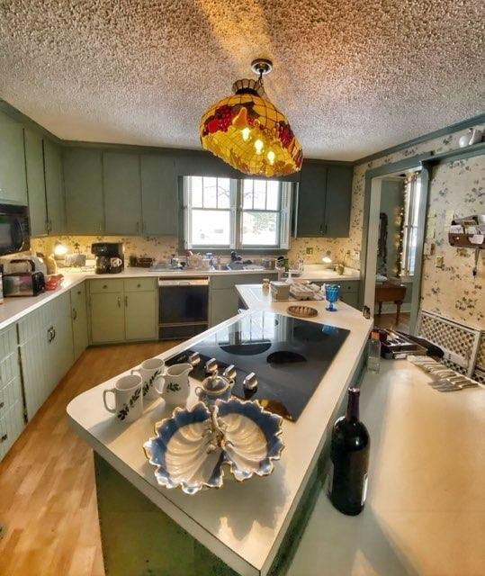 kitchen featuring dishwashing machine, light countertops, black microwave, and green cabinetry