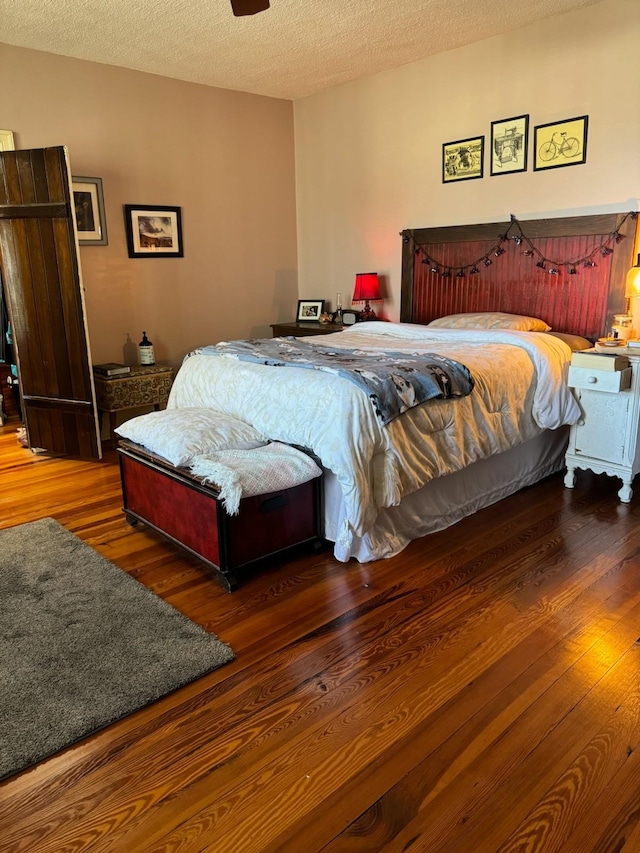 bedroom with a textured ceiling and wood finished floors