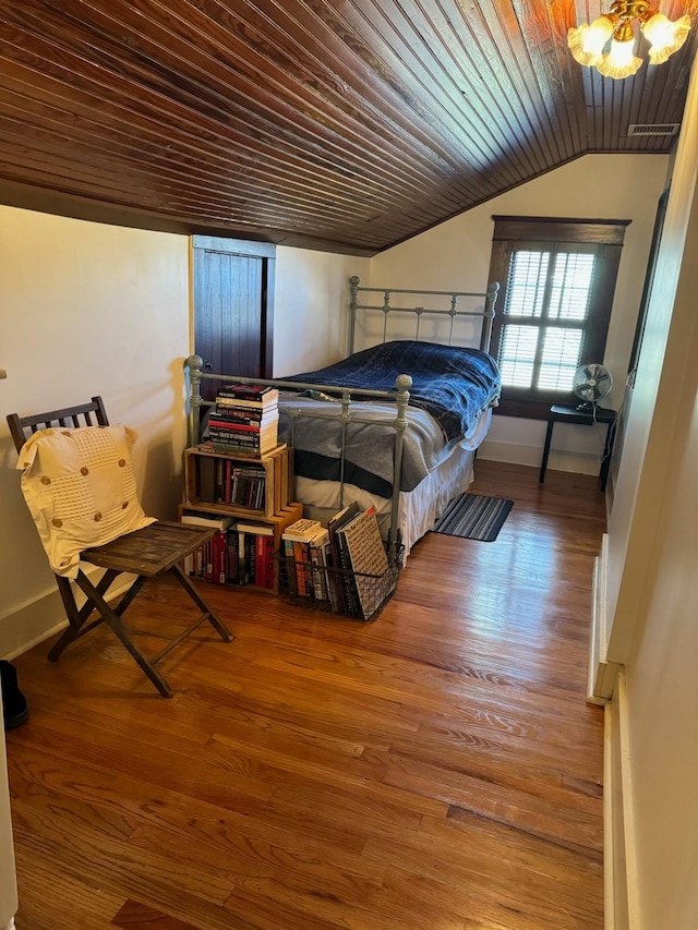 bedroom with wood finished floors, visible vents, baseboards, vaulted ceiling, and wood ceiling