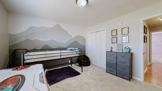 carpeted bedroom featuring a closet, a textured ceiling, and baseboards