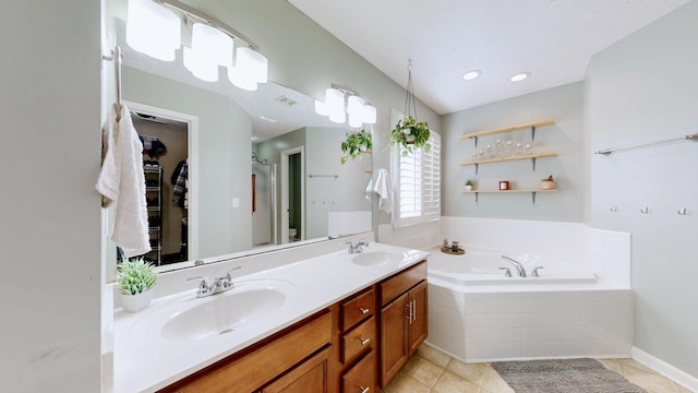 bathroom with tile patterned floors, double vanity, a bath, and a sink