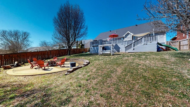 view of yard featuring a deck, a fire pit, a fenced backyard, and a patio area