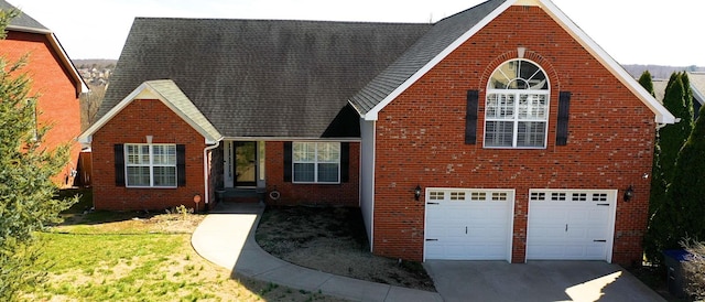 view of front of home featuring a garage, a front yard, brick siding, and driveway