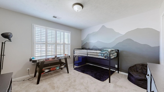 carpeted bedroom featuring visible vents, baseboards, and a textured ceiling