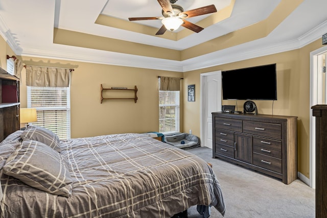 bedroom featuring multiple windows, a raised ceiling, light carpet, and crown molding