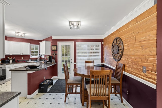 dining area with light floors, crown molding, and baseboards