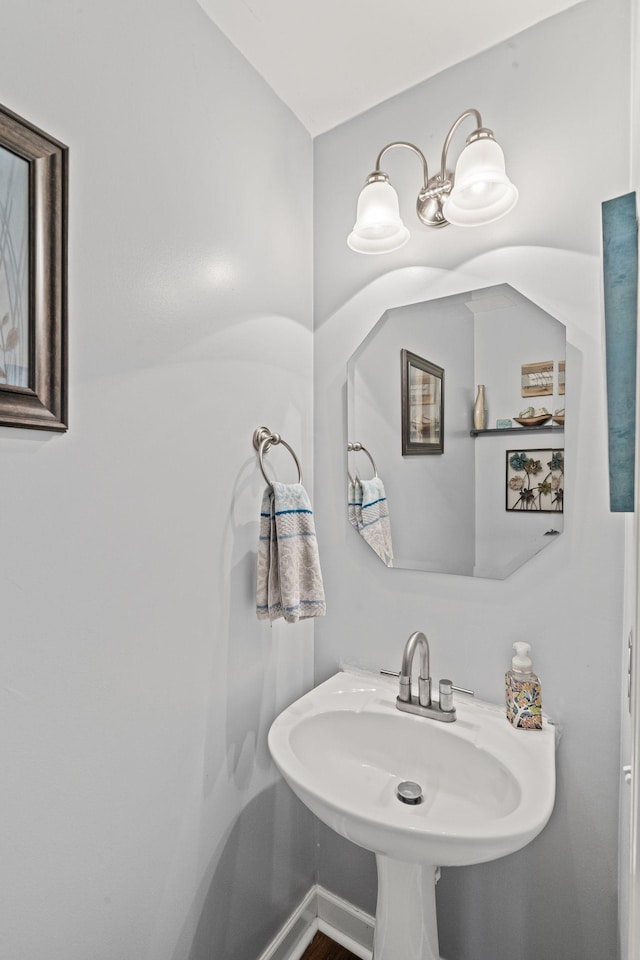 bathroom featuring baseboards and a sink