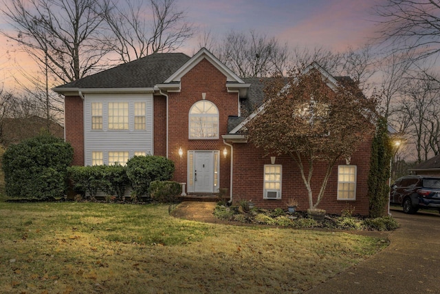 view of front of house featuring a yard and brick siding