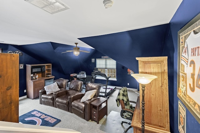 home theater featuring a ceiling fan, carpet, visible vents, baseboards, and vaulted ceiling