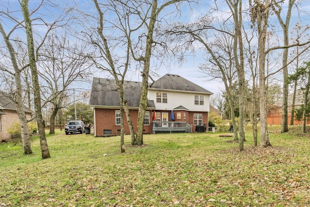 rear view of house with a deck, a lawn, brick siding, and crawl space