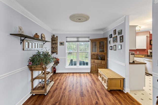 interior space with dark wood-style floors, crown molding, and baseboards