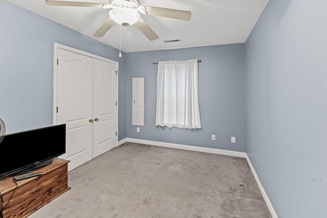 unfurnished bedroom featuring a closet, a ceiling fan, baseboards, and carpet floors