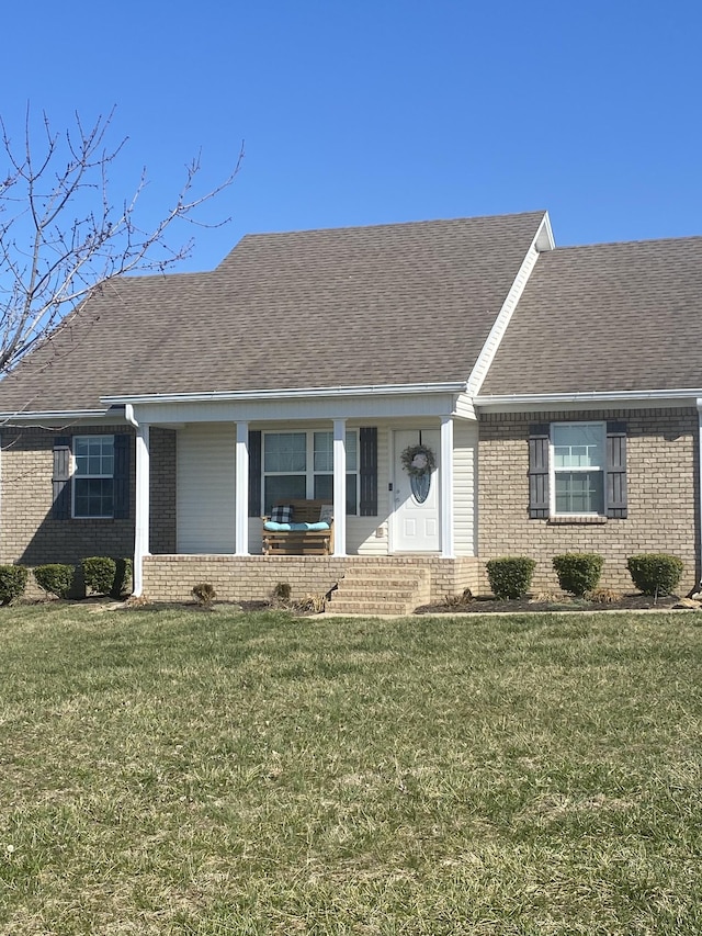 ranch-style house with brick siding, roof with shingles, and a front yard