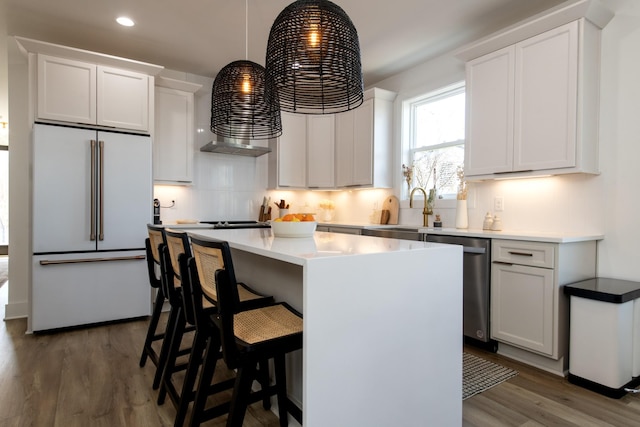 kitchen with a kitchen island, high end white refrigerator, dark wood finished floors, decorative backsplash, and dishwasher