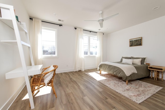 bedroom with light wood-type flooring, baseboards, and ceiling fan